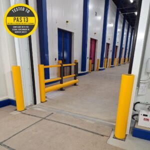 Four Protection Bollards at a warehouse shutter door with a barrier run and additional bollards lining the hallway