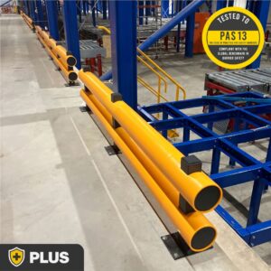 Two long runs of polymer Double Bumper Barriers with a gap for a yellow staircase in a warehouse, shown with the PAS 13 testing logo and Brandsafe Safety Plus Range logo.
