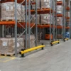 Yellow and grey SpaceSaver Bumper Barrier protecting warehouse racking from impact.