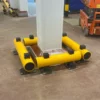 Yellow polymer single bumper barrier installed around a structural column in a food manufacturing facility to prevent vehicle impact damage.