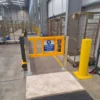 Pedestrian safety gate and polymer barriers protecting a marked walkway between warehouse stillages