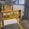 Wide view of a protected pedestrian walkway, loading bay doors and marked crossing in a logistics centre