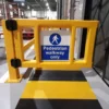 Close up of a yellow polymer pedestrian safety gate beside a warehouse loading bay crossing
