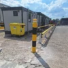 Yellow Armco 760HR safety barrier and ImpactSAFE Bollard positioned outside a site office to provide impact protection and improve workplace safety.