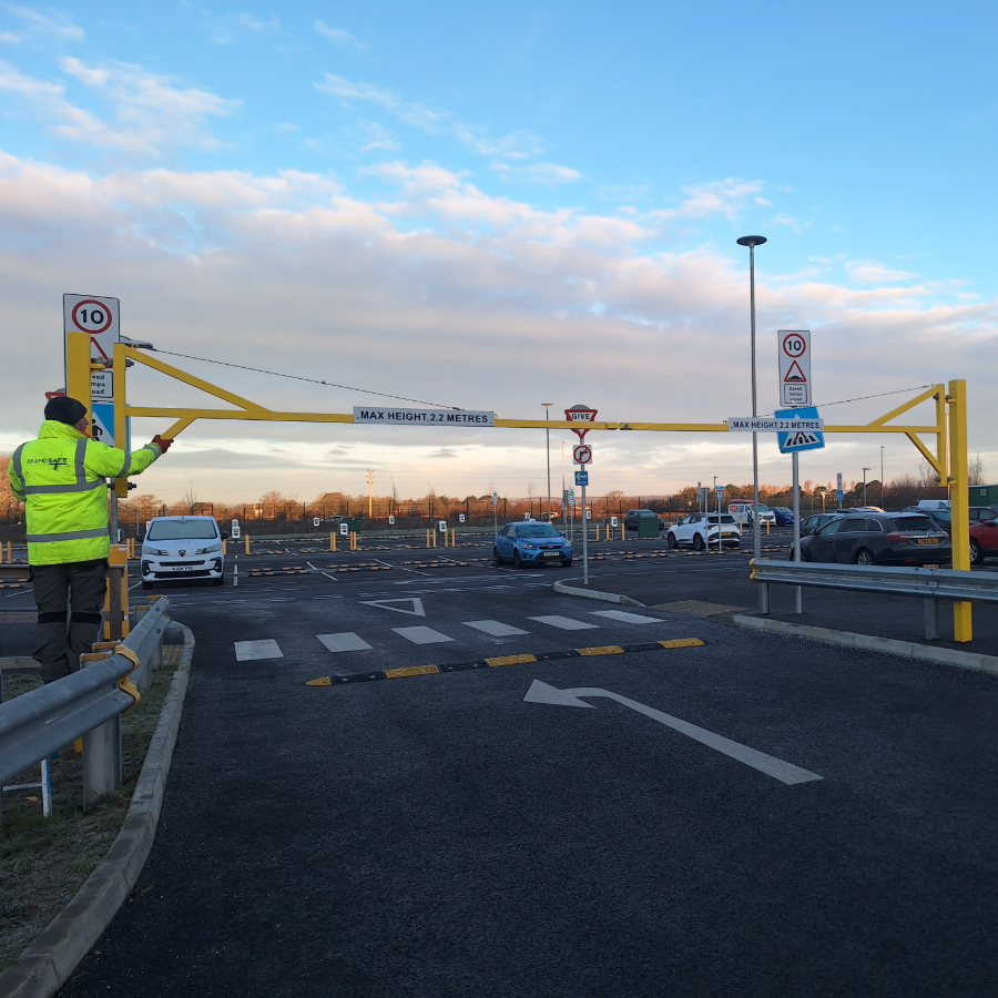Brandsafe specialist working on a yellow height-restriction barrier at a car park entrance