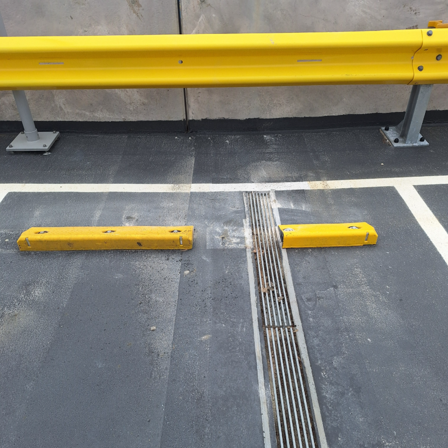 Yellow wheel stop snapped in half following impact damage