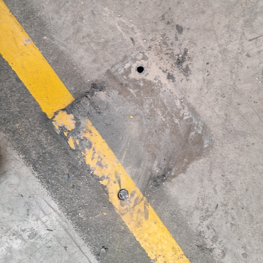 Armco barrier baseplate pulled from a damaged concrete floor with two anchors fitted